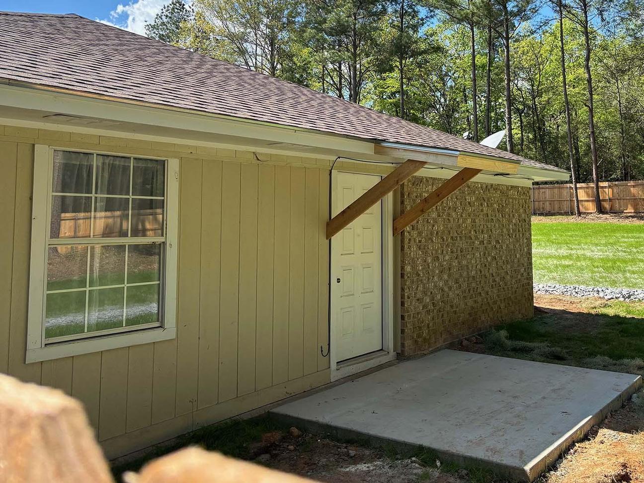Stained wood privacy fence extending along a residential backyard with treated wood posts