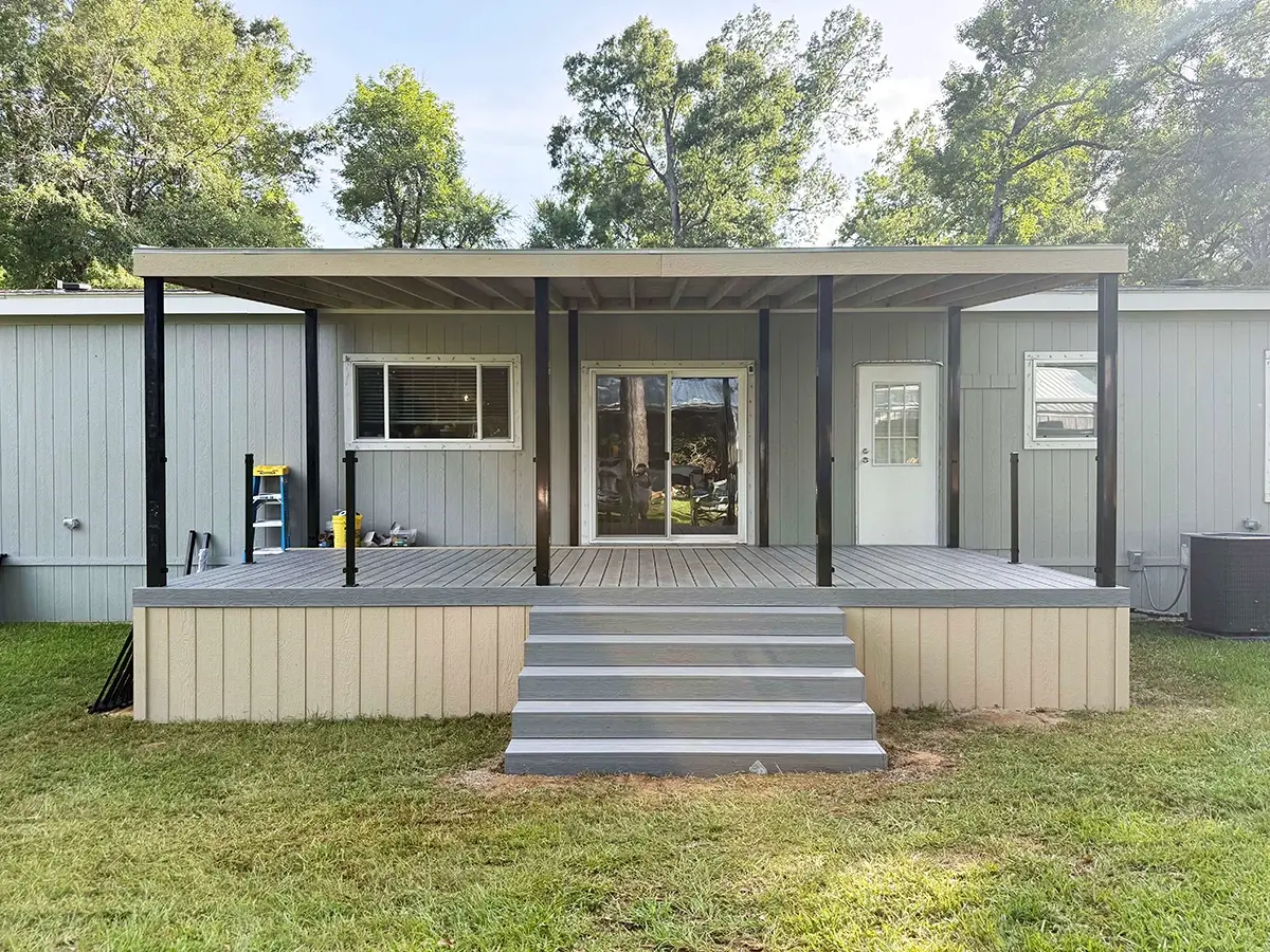 Composite deck with stairs installed on the front porch of a home under an awning