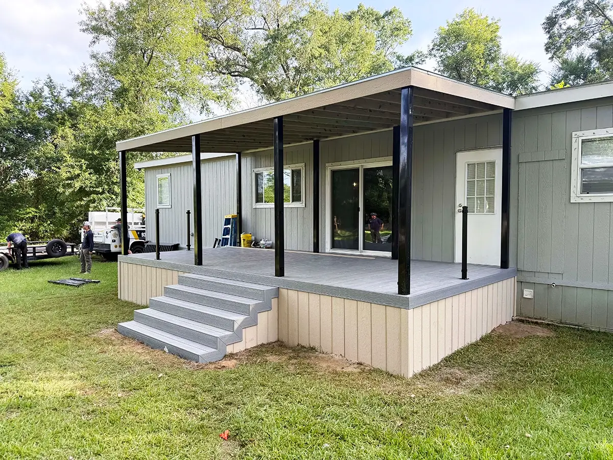Newly constructed covered composite deck attached to the side of a home