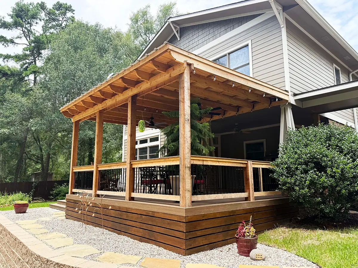 Custom-built backyard wood deck with an attached covered pergola structure