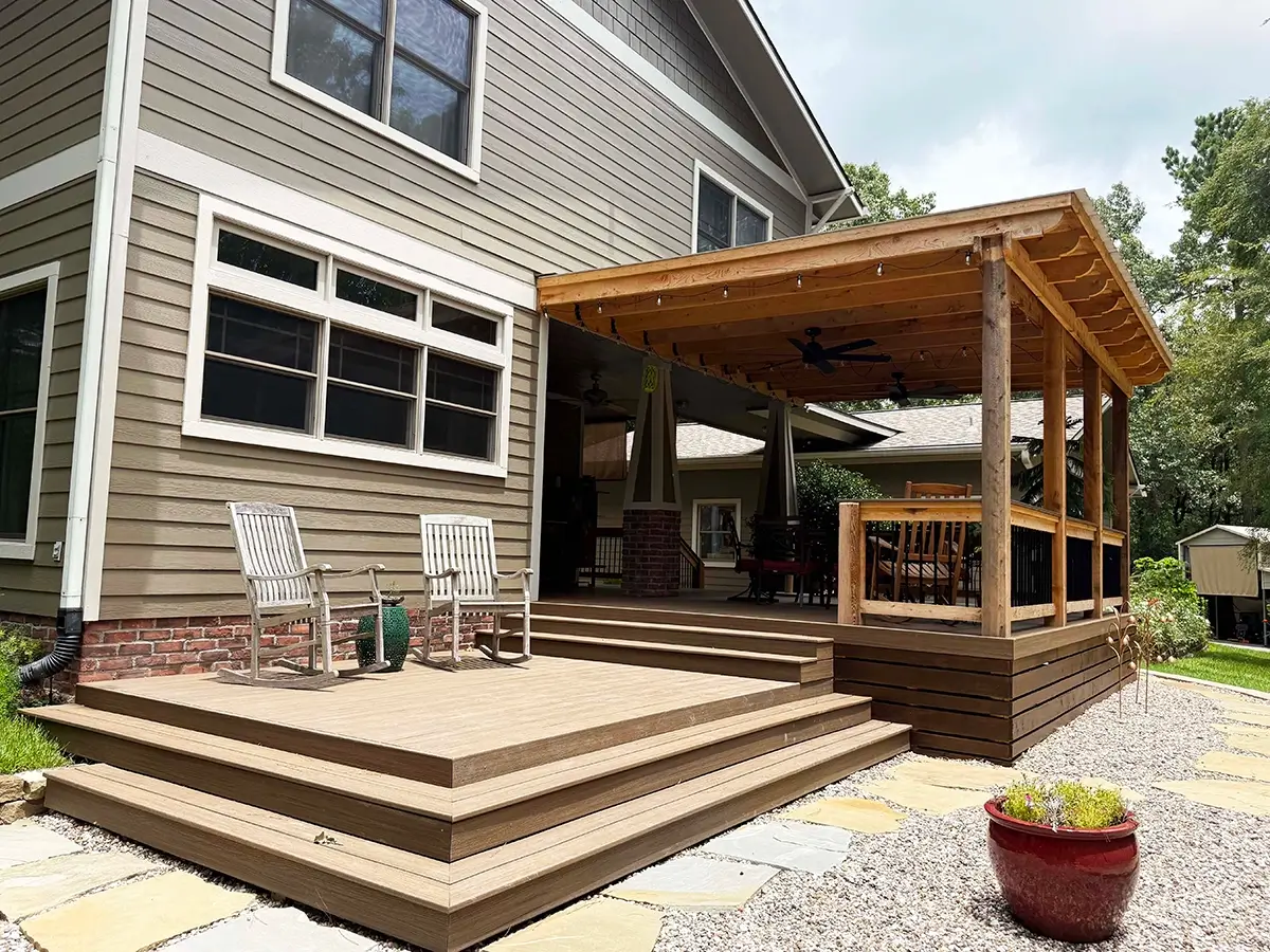 Wood deck installed on the front porch of a home with stairs going up to the deck
