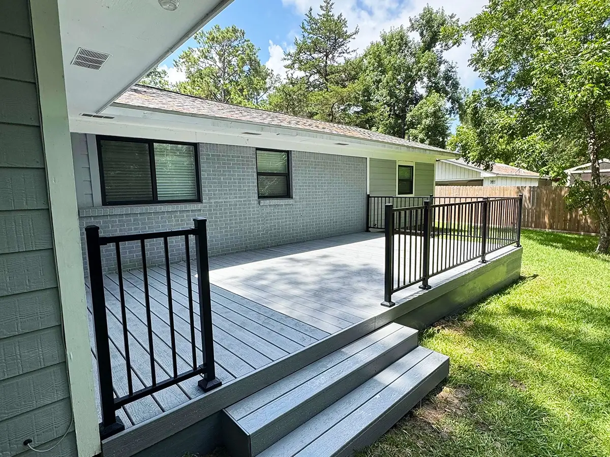 Composite deck with aluminum railings installed off the side of a home