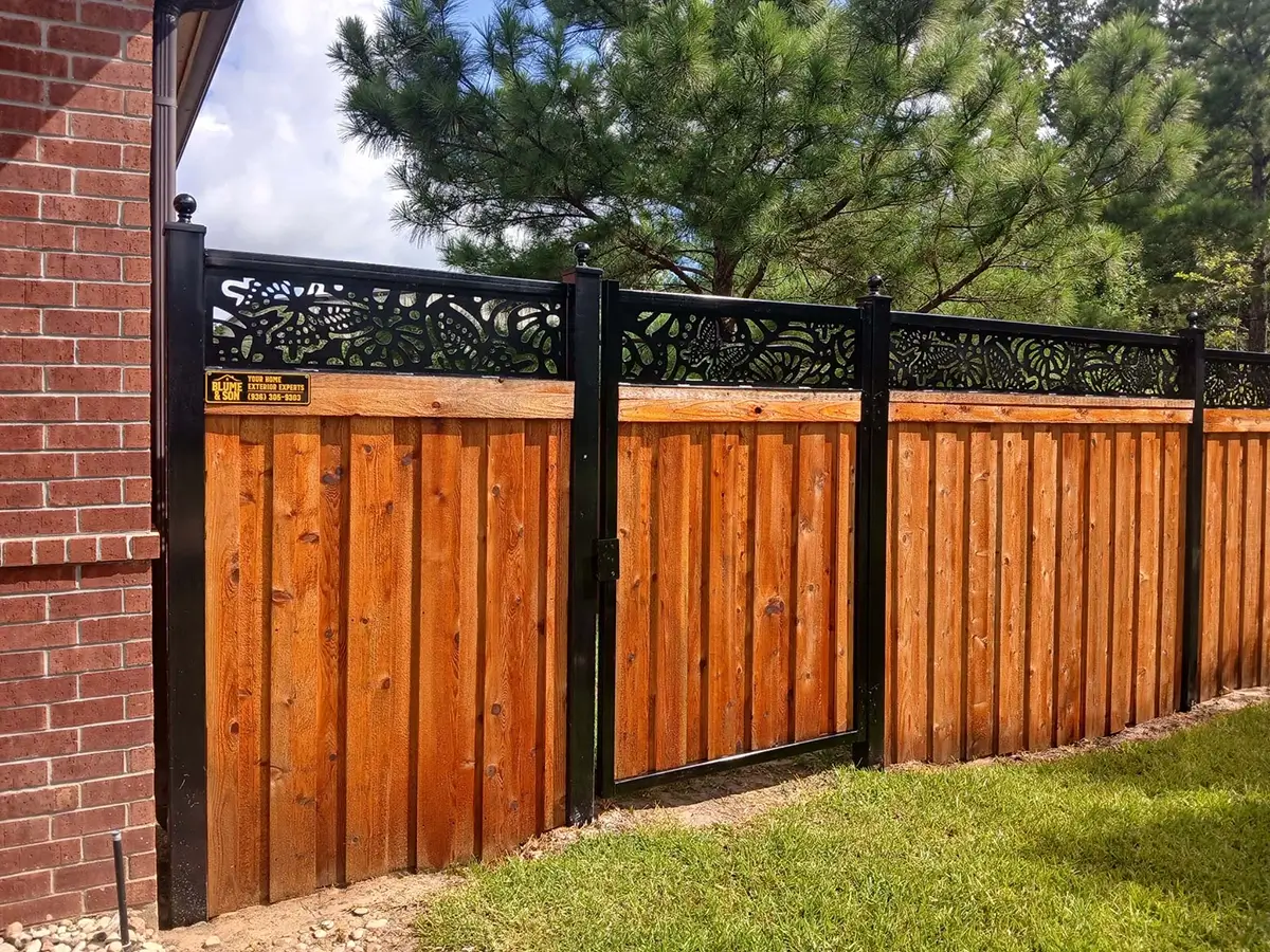 Mixed material fence with board on board wood fence that has a metal decorative frame