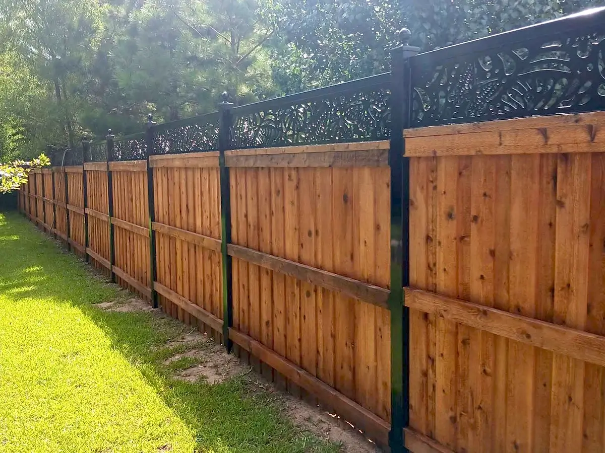 Specialty fence with a full privacy board on board that has a metal frame with a decorative accent