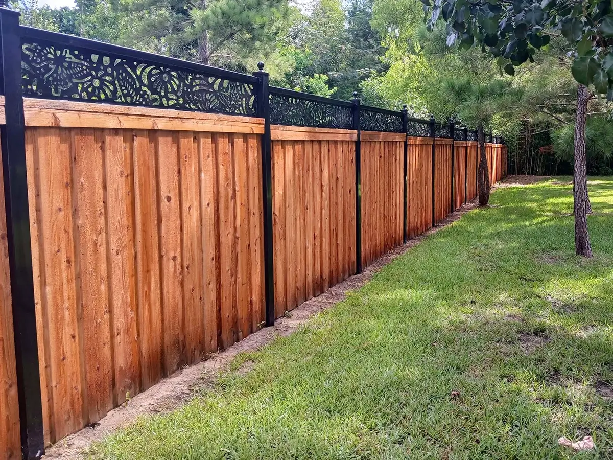 Specialty fence with a full privacy board on board that has a metal frame with a decorative accent