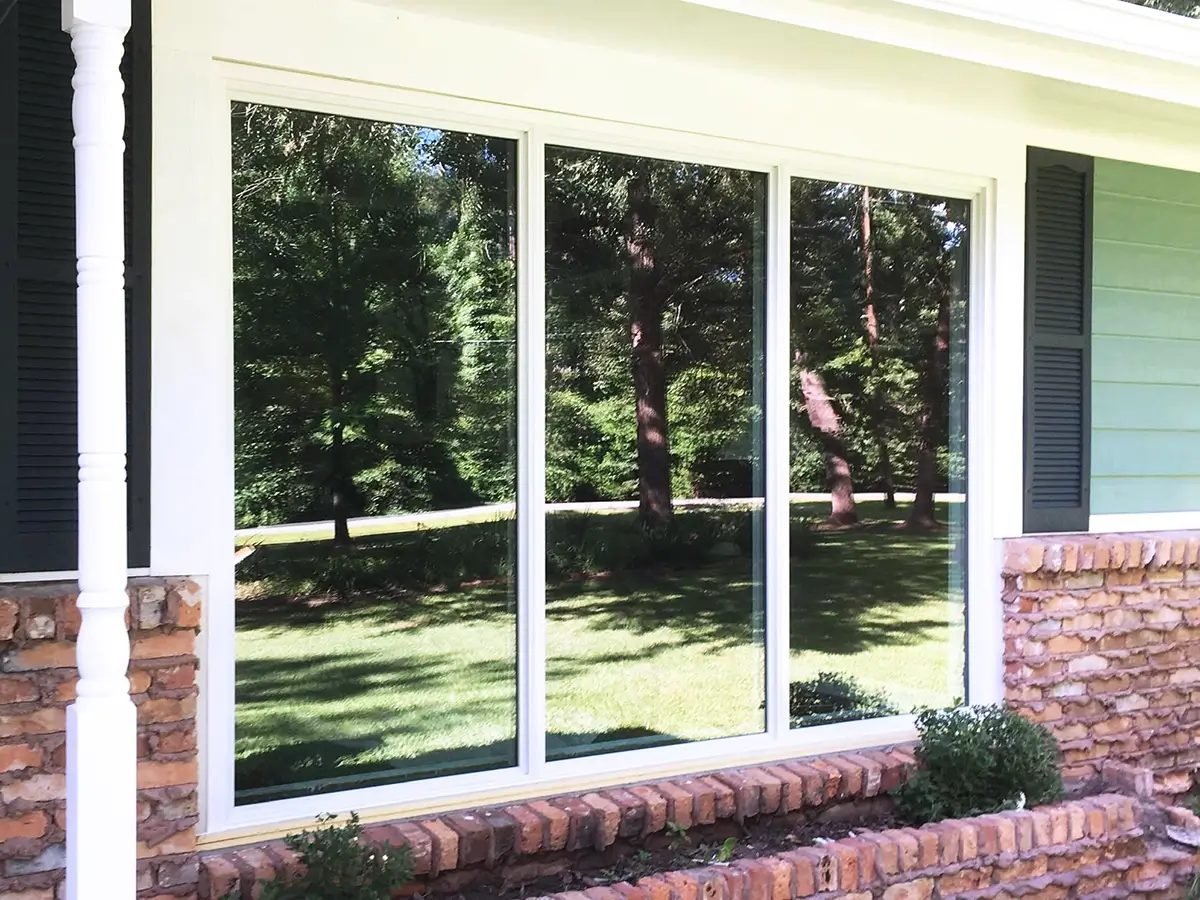 Residential sliding vinyl windows installed on a home with red brick