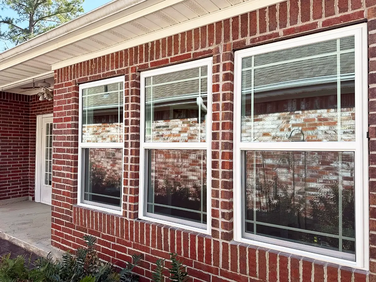 3 vinyl windows installed on the front of a brick home