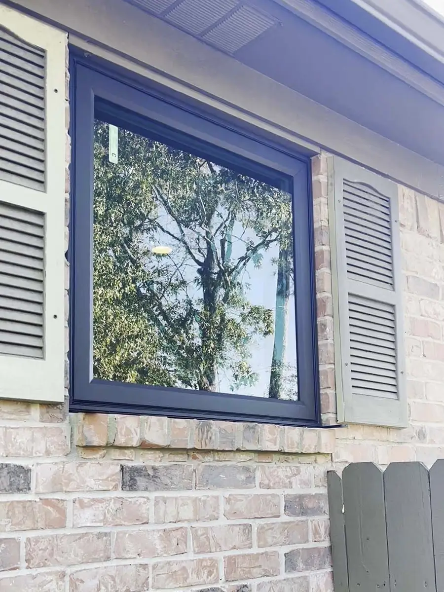 Aluminum window installed on a brick wall with shutters