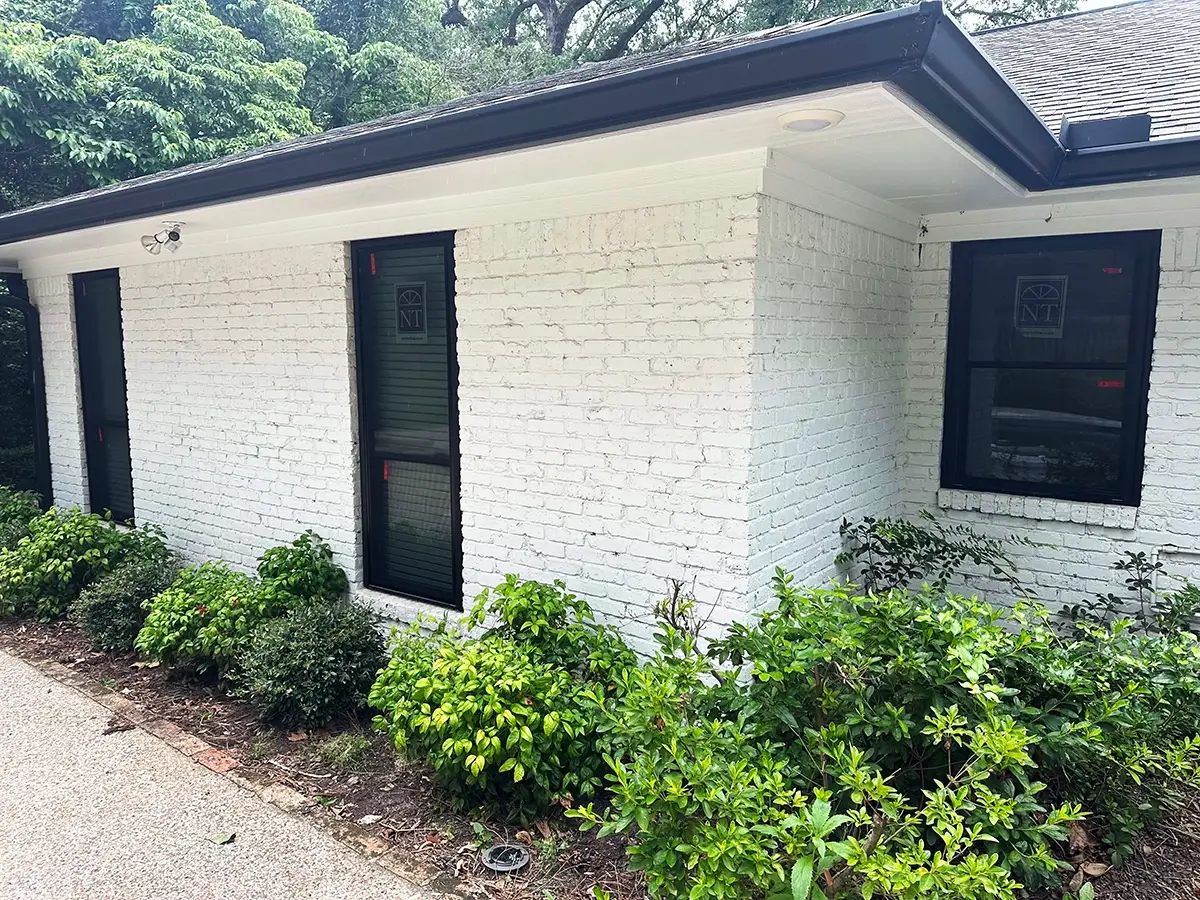 Aluminum windows installed on a white brick home