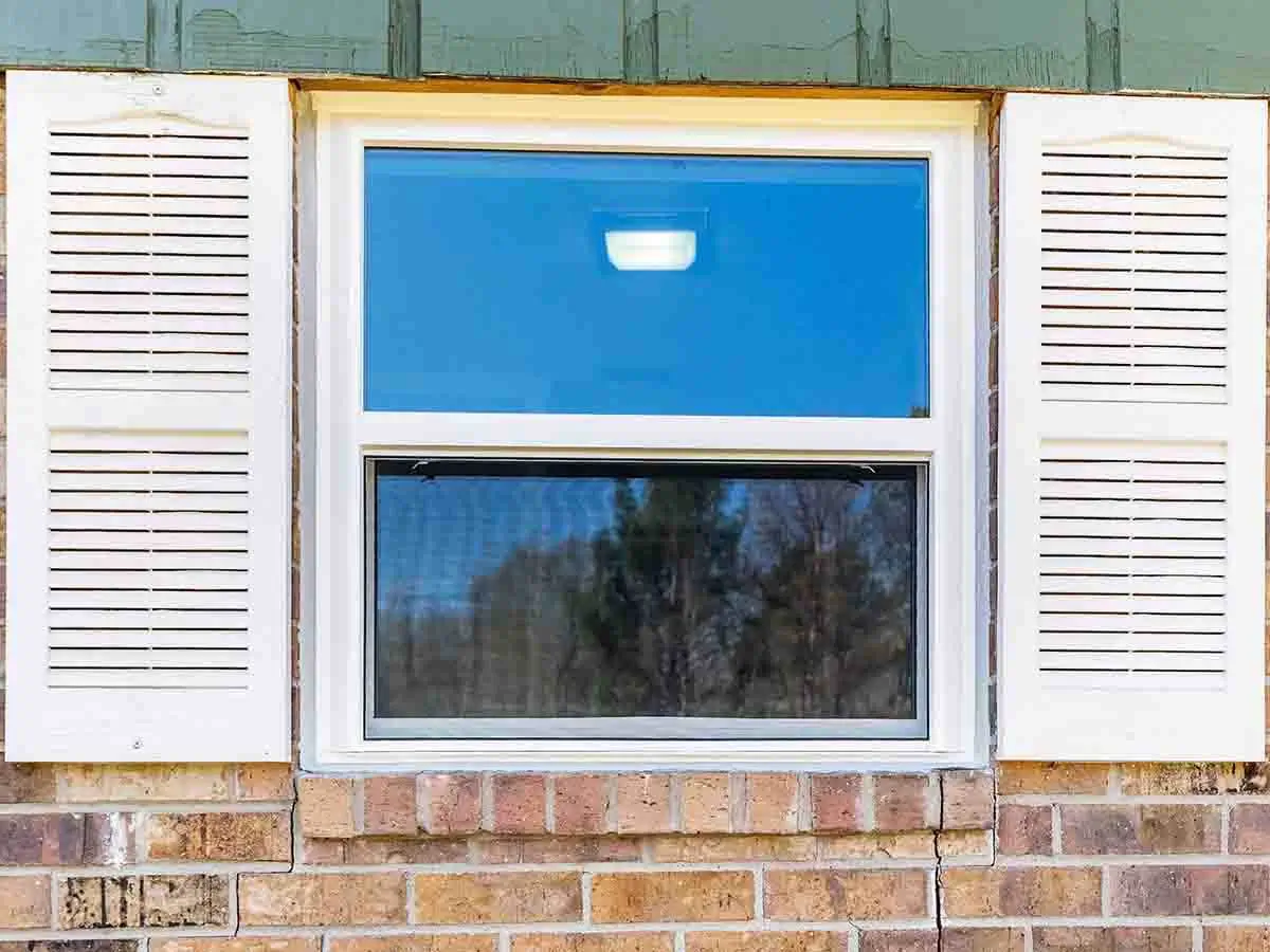 Blume & Son Construction Installing a vinyl window onto a home